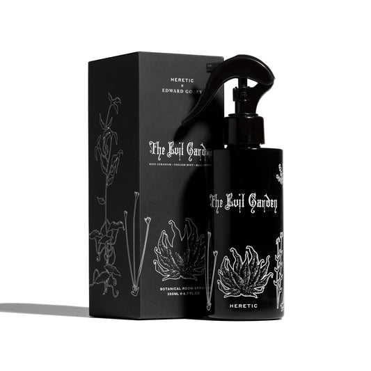 Black spray bottle and packaging with 'The Evil Garden' and 'Heretic' branding on a white background