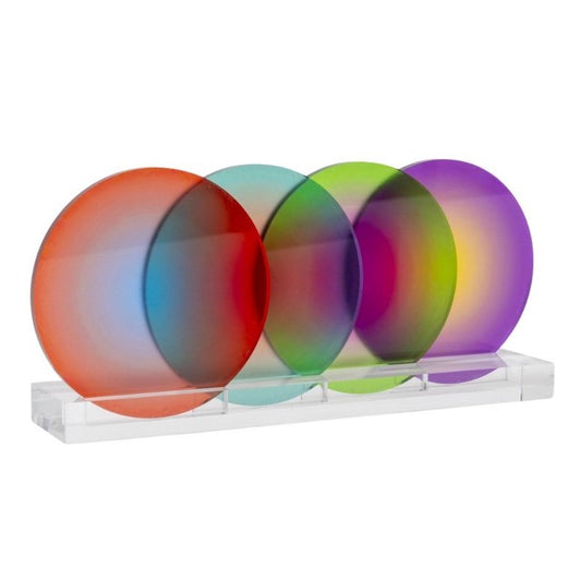 A set of four gradient color circled coasters in red, orange, yellow, and purple, displayed on a clear stand.