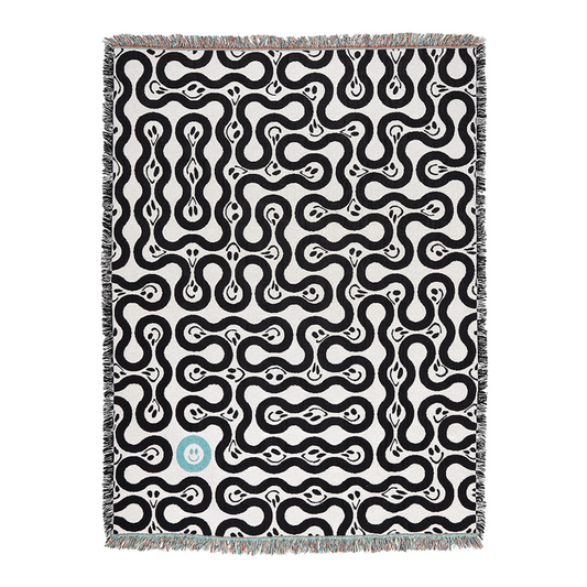 A black and white geometric patterned throw with fringed edges.