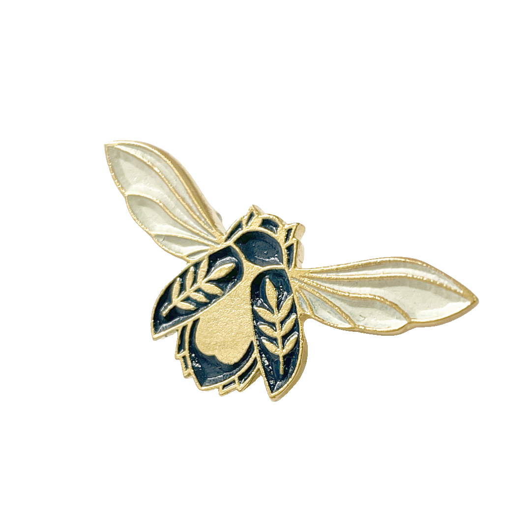 A pin with a design inspired by mythical botanicals, featuring a gold-colored body with blue and white details.