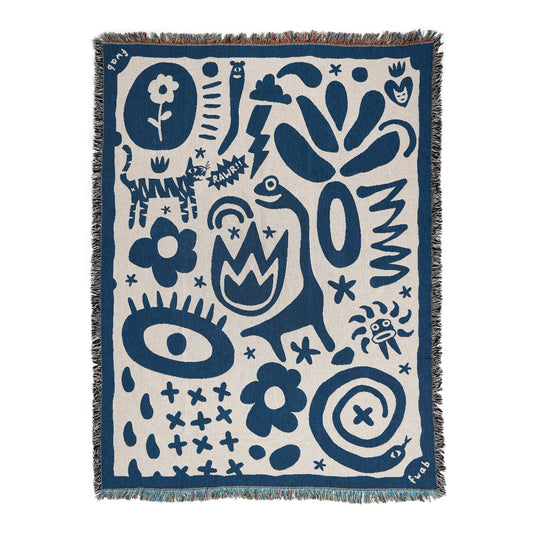 A blue and white throw blanket with various abstract and geometric patterns, featuring a fringed edge.