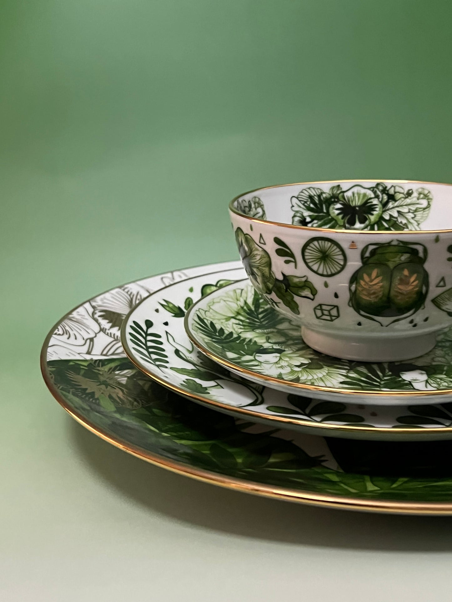 Tea cup and saucer with green botanical design on a green background