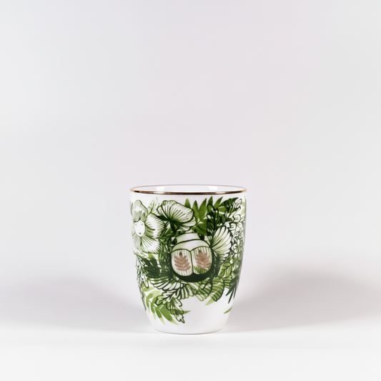 Ceramic mug with green leaf pattern on a white background