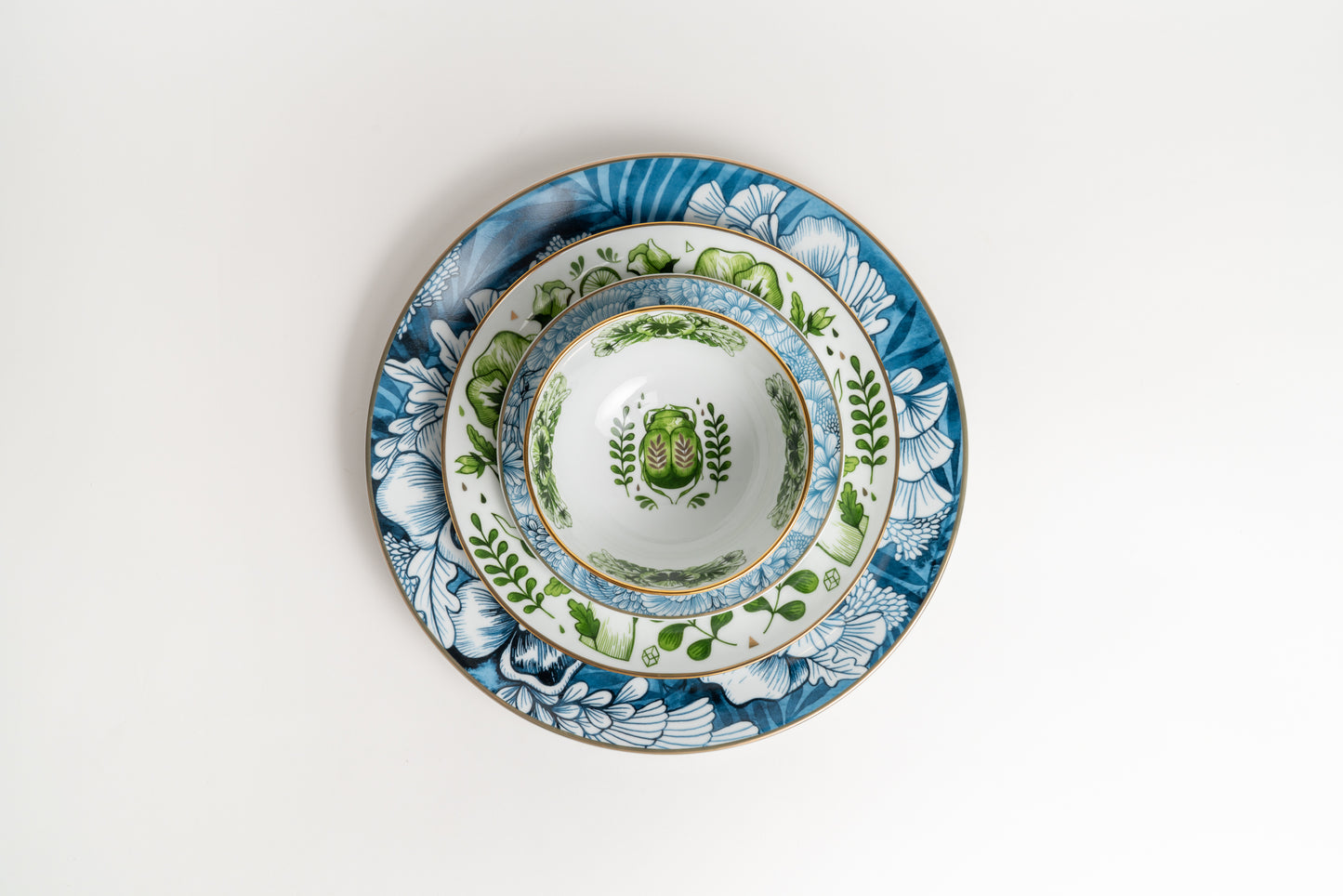 Stack of decorative ceramic plates with floral patterns on a white background