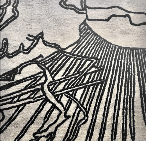 Textured surface with black line art of a mountain landscape on a gray background