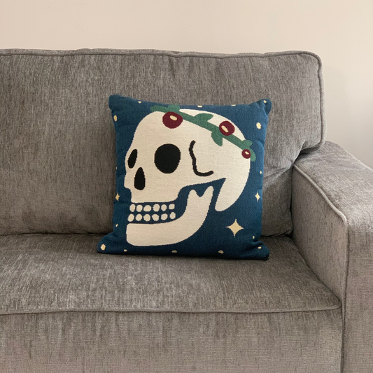 Decorative pillow with a skull design on a gray sofa