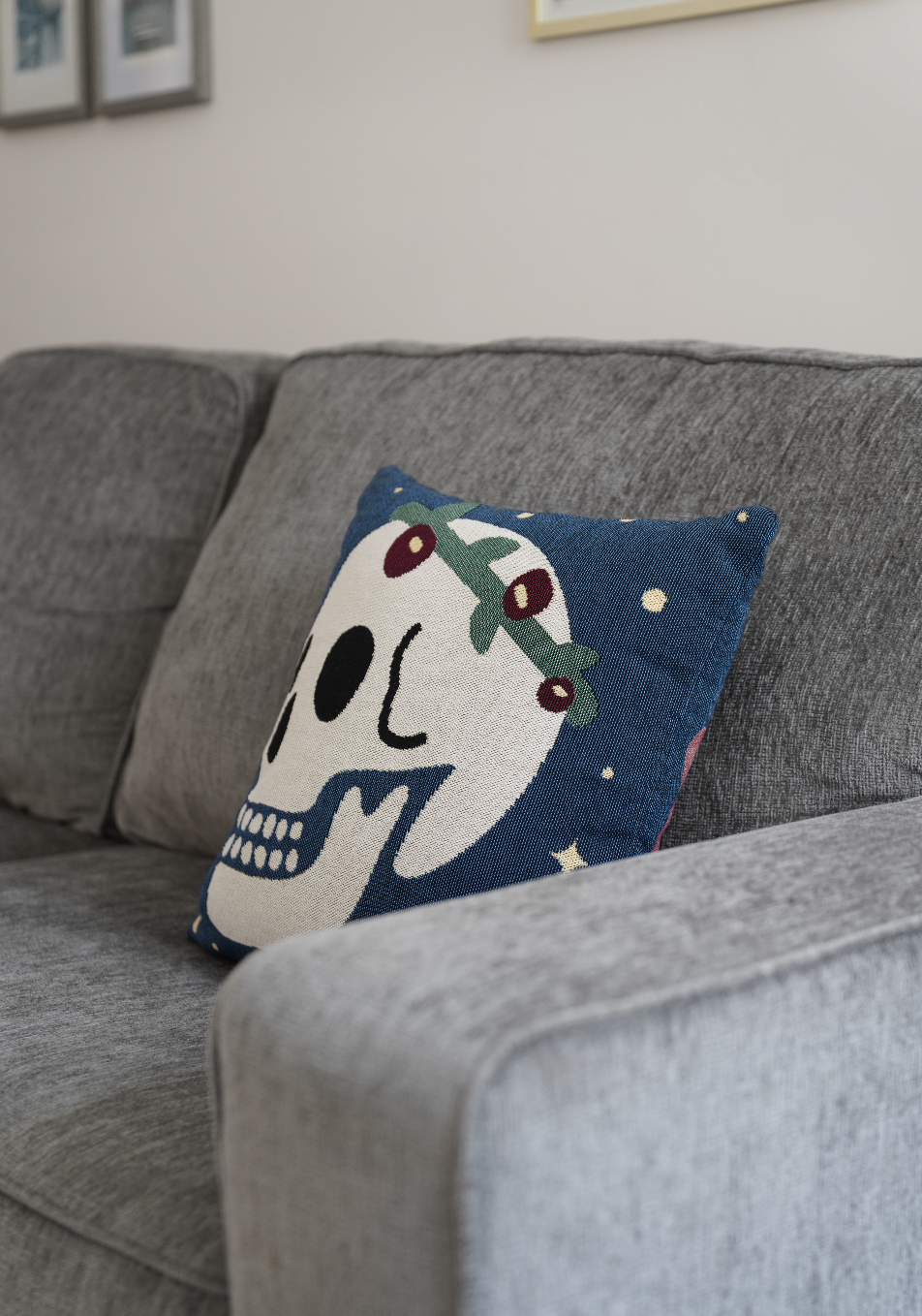 Decorative pillow with a skull design on a gray couch