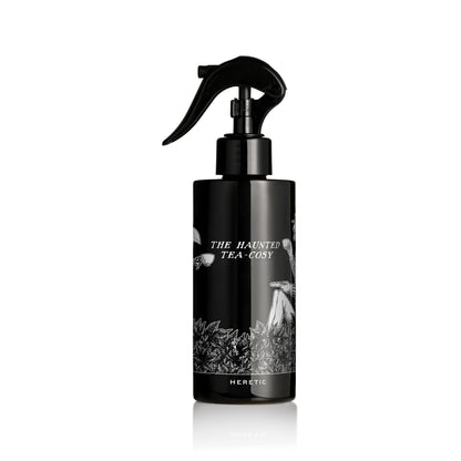 Black spray bottle with decorative label on a white background
