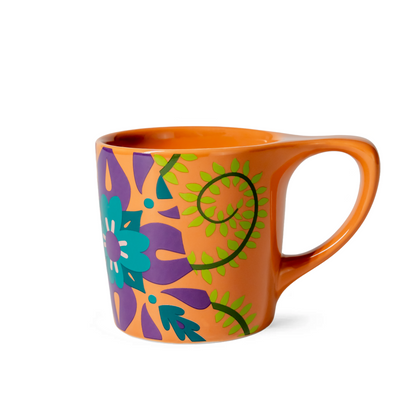 Orange mug with colorful floral design on a white background