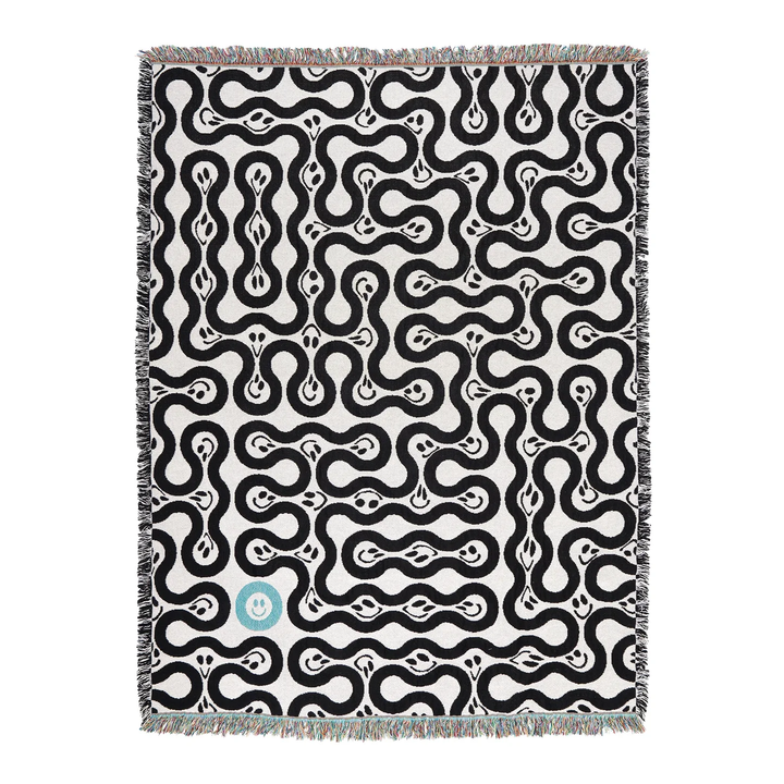 Woven blanket with black and white abstract pattern on a white background