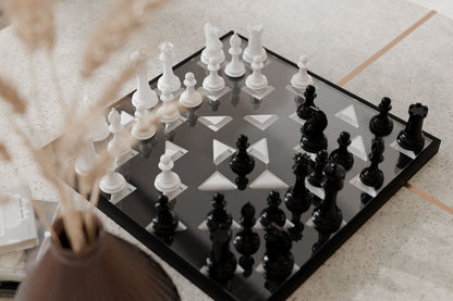 Chessboard with black and white pieces on a light surface