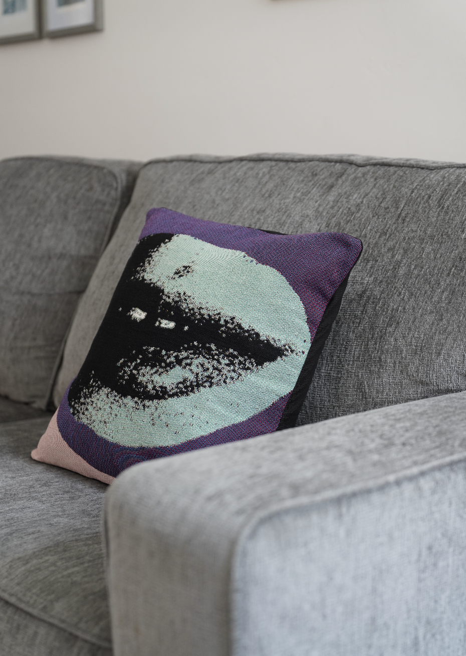 Decorative pillow with a face design on a gray sofa