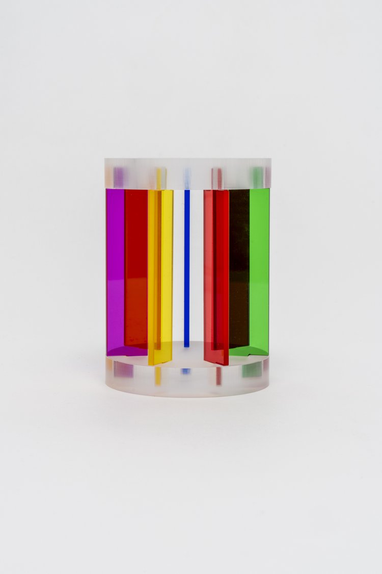 A multicolored acrylic Rainbow Pencil Cup designed by Yoni Alter with vertical stripes of various colors.