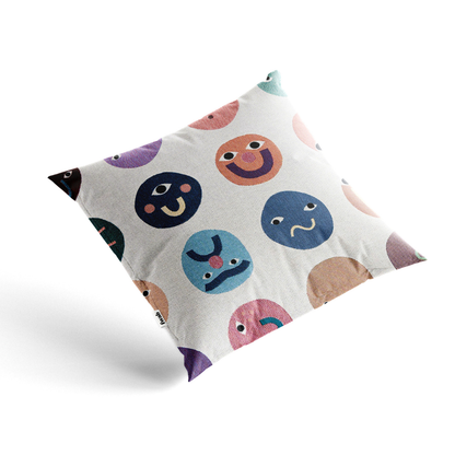 Decorative pillow with colorful smiley face patterns on a white background