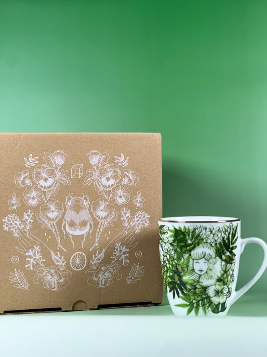 Cardboard box and mug with floral designs on a green background