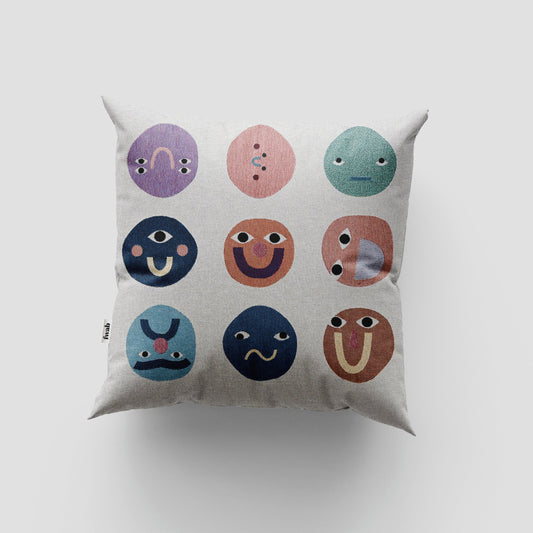 Decorative pillow with colorful smiley face patterns on a light gray background