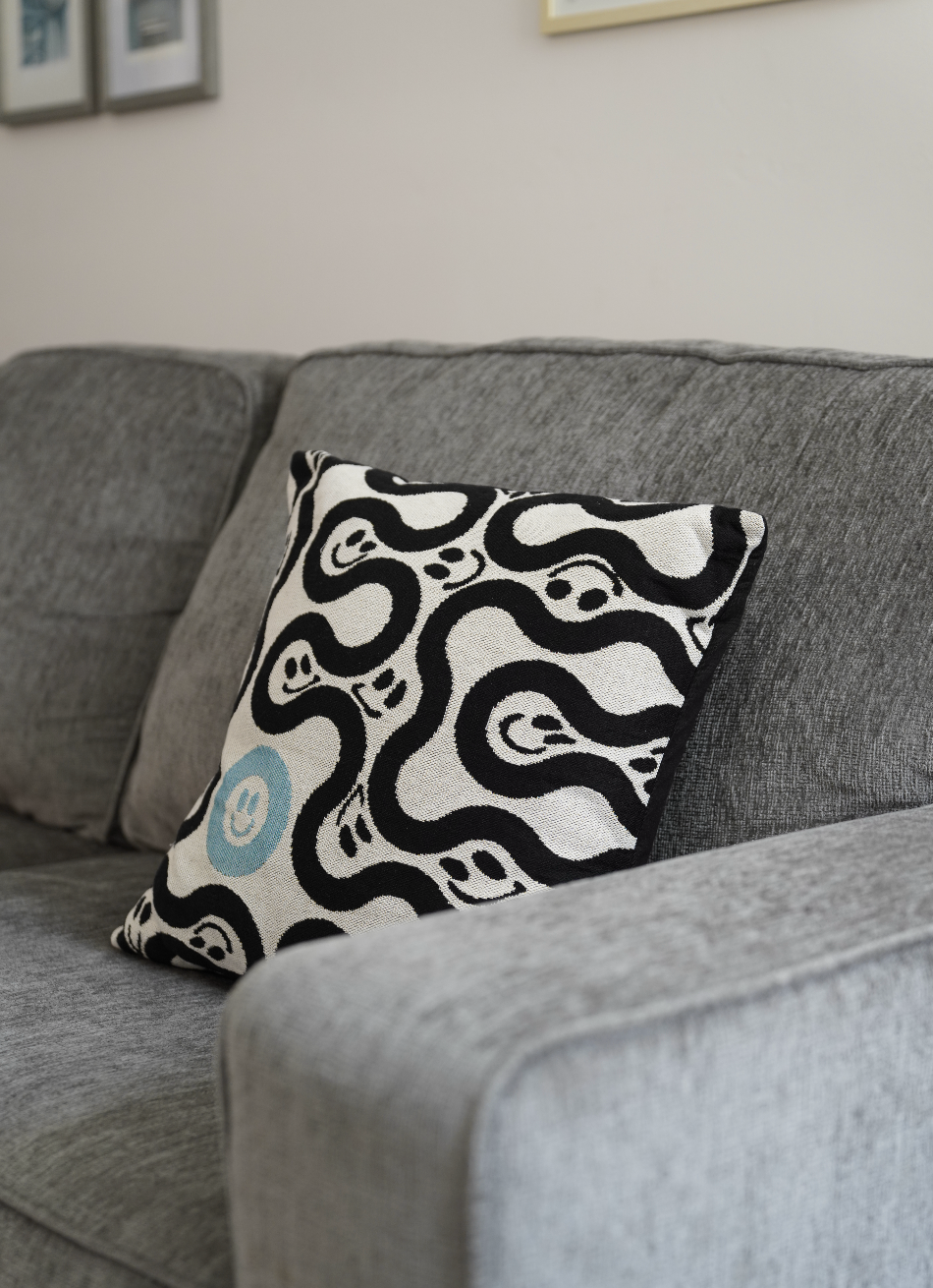 Decorative pillow with black and white pattern on a gray sofa