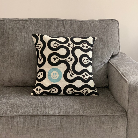 Decorative pillow with black and white pattern on a gray sofa