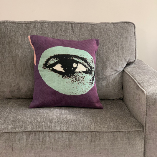 Decorative pillow with eye design on a gray couch