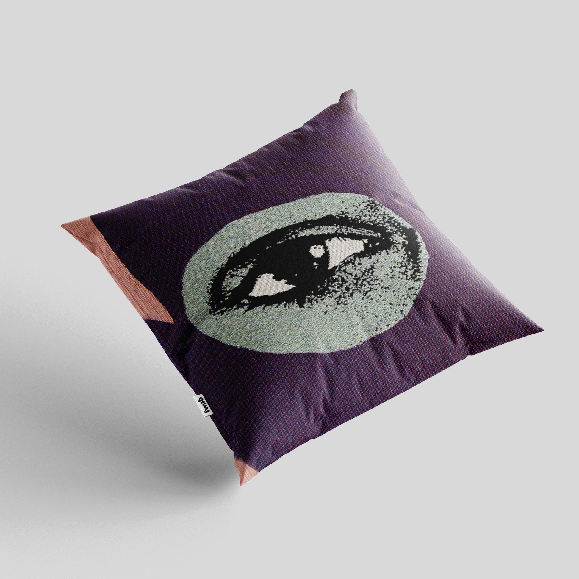 Decorative pillow with eye design on a plain background