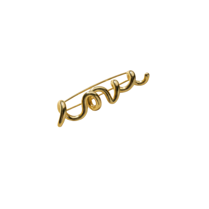 Gold 'love' brooch on a white background