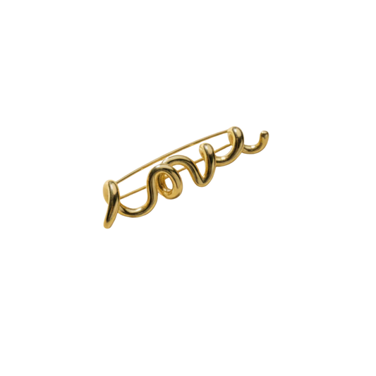 Gold 'love' brooch on a white background