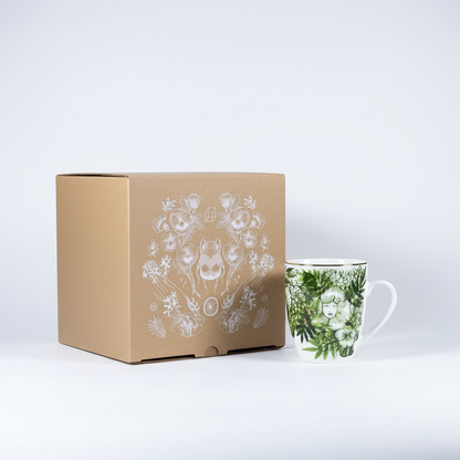 Cardboard box with floral design next to a mug with a similar design on a white background