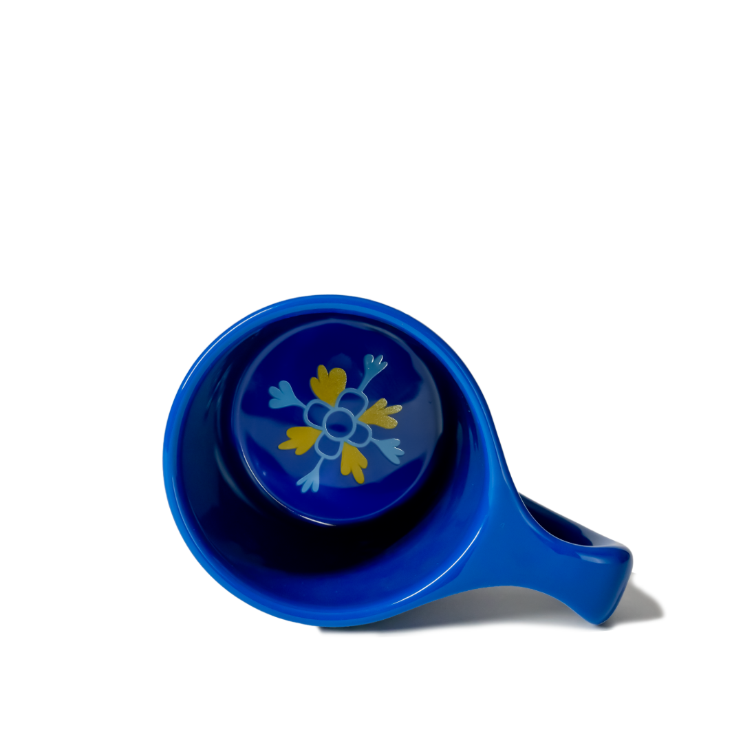 Blue ceramic teacup with floral design on a white background