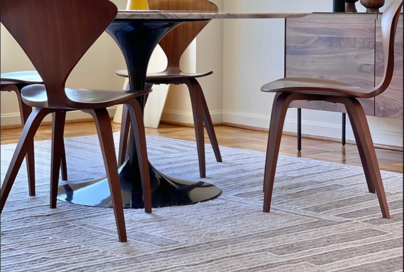 Dining table with wooden chairs on a patterned rug