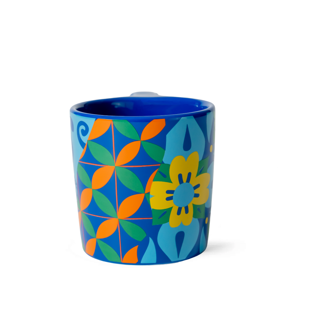 Blue mug with colorful geometric floral pattern on a white background
