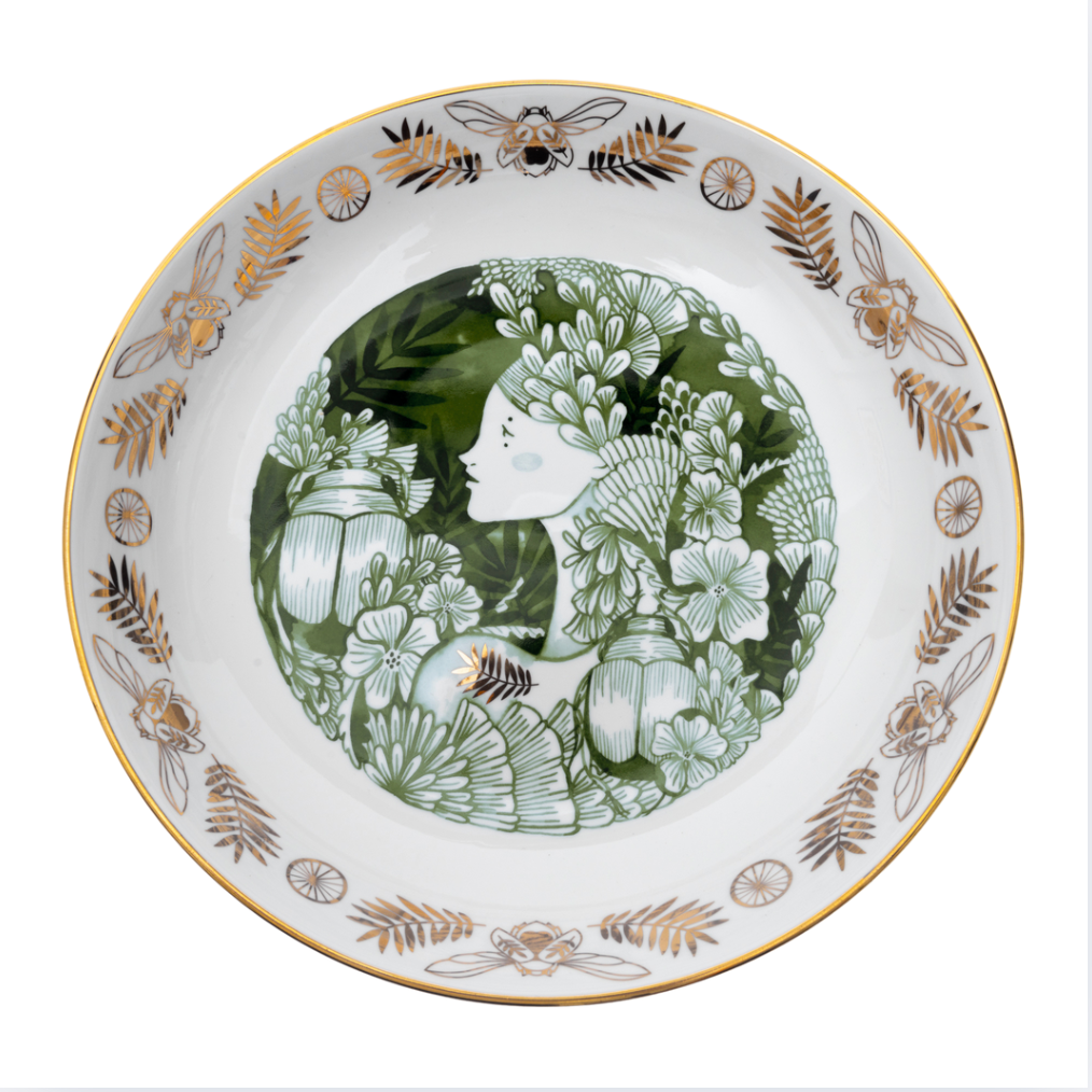 Decorative plate with floral and insect design on a white background
